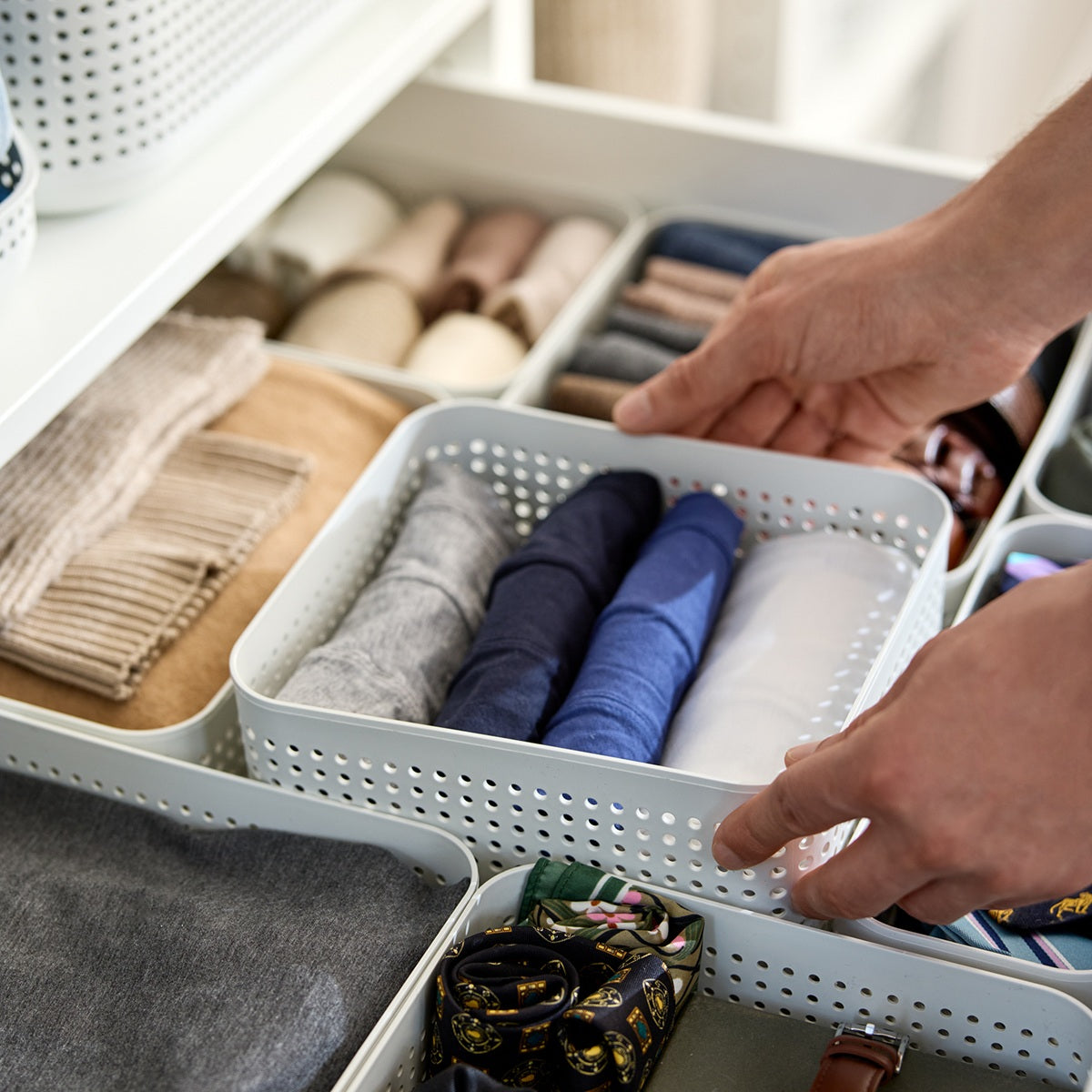Richtig eingeräumte Garderobe mit nach Farben sortierter Kleidung und Rotho Aufbewahrungssystemen für ein ordentliches Gesamtbild.